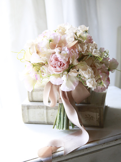 淡いピンクのスイトピーと胡蝶蘭のクラッチブーケ・ブートニア