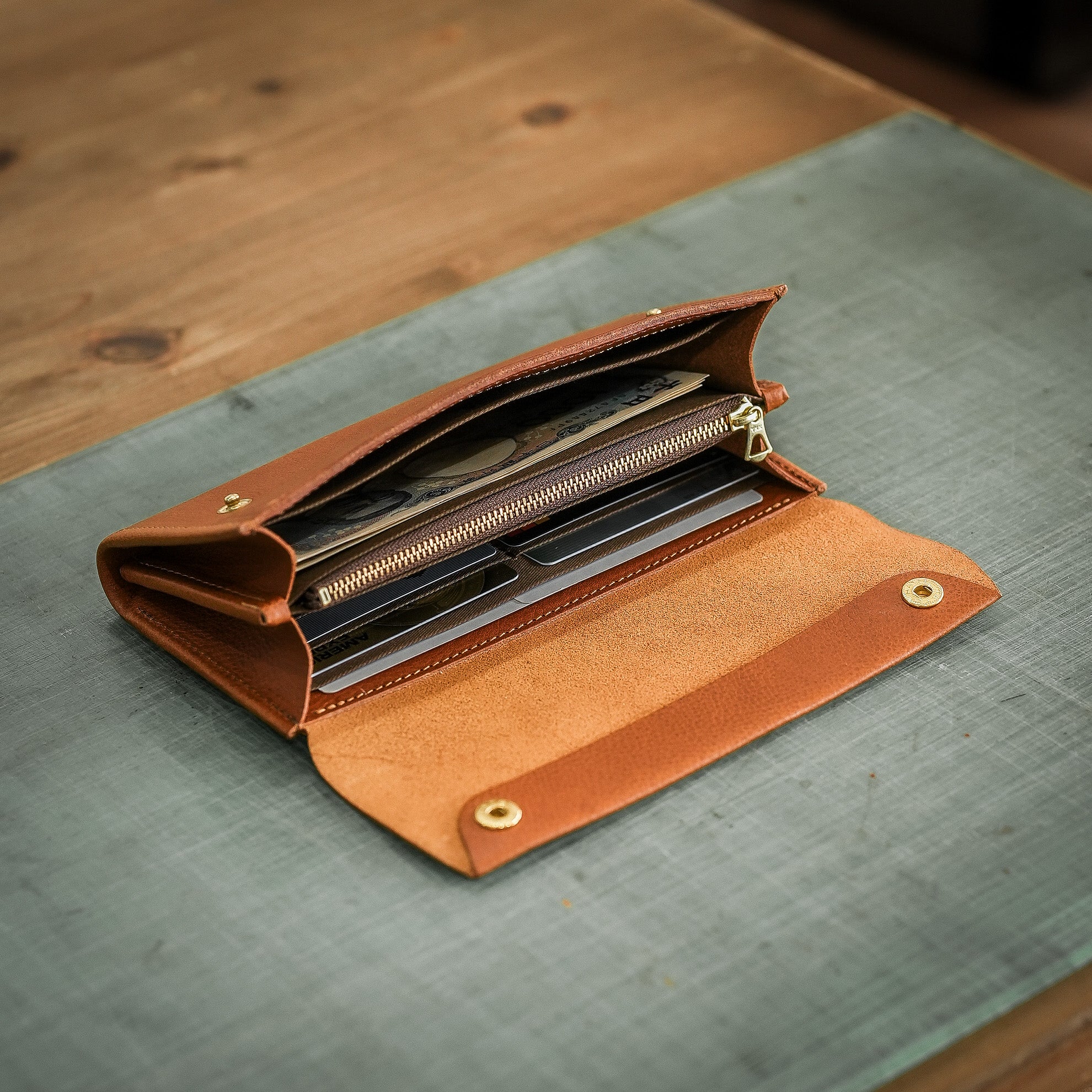 金具を隠した一枚革】ふっくらと包み込む、くるみホックの長財布