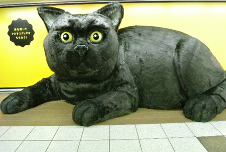 東京都・新宿駅に幅6mの巨大黒猫が登場! 鼻を押すとプレゼントが出て